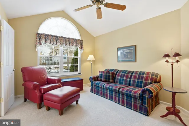 a living room with furniture a ceiling fan and a window