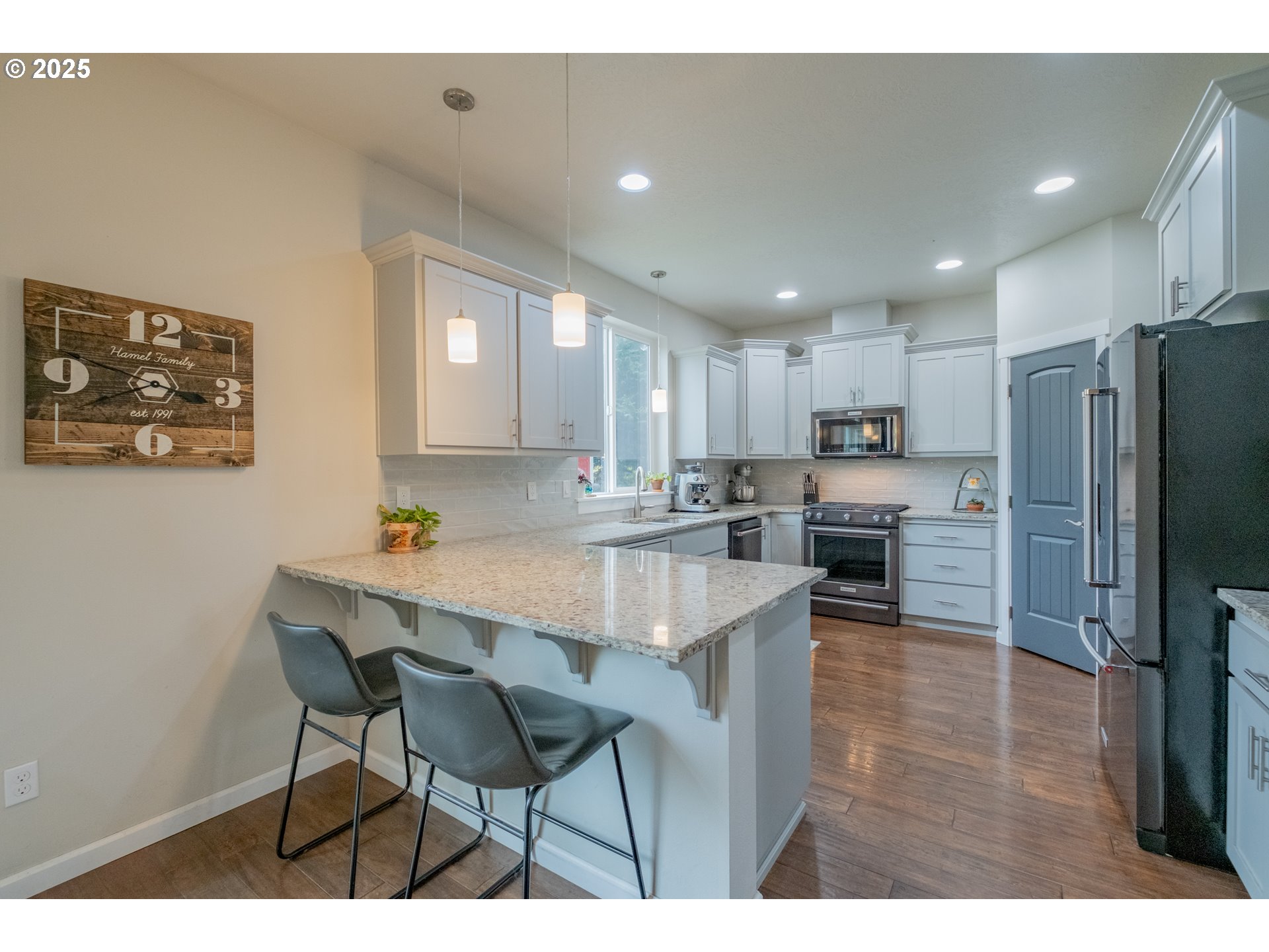 405 Northwest Juniper Lane Albany, OR 97321 - Photo 11 of 48 a kitchen with stainless steel appliances granite countertop a refrigerator a stove a sink a dining table and chairs with wooden floor