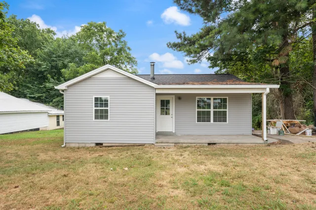 a front view of house with yard and trees around