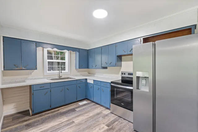 a kitchen with stainless steel appliances granite countertop a refrigerator and a sink