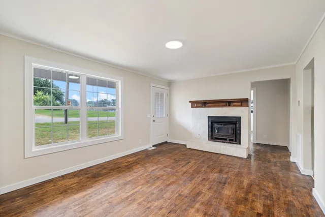 an empty room with fireplace and windows