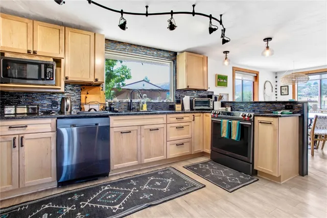 a kitchen with stainless steel appliances granite countertop a stove a sink and a microwave