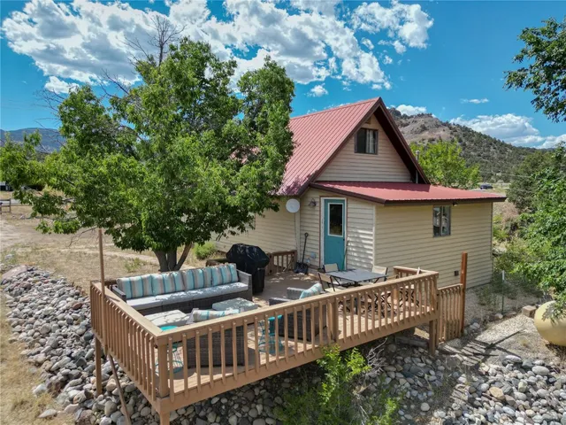 a view of house with a deck and furniture