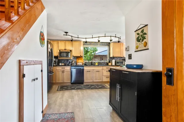 a kitchen with stainless steel appliances kitchen island granite countertop a refrigerator and a stove top oven