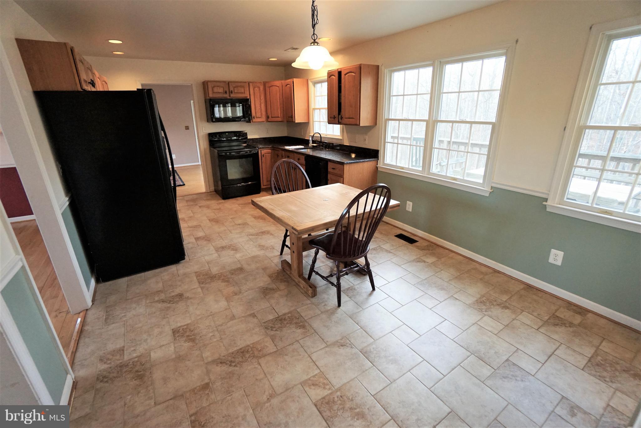 5940 Free State Road Marshall, VA 20115 - Photo 8 of 30 a kitchen with stainless steel appliances kitchen island granite countertop a refrigerator and a stove top oven