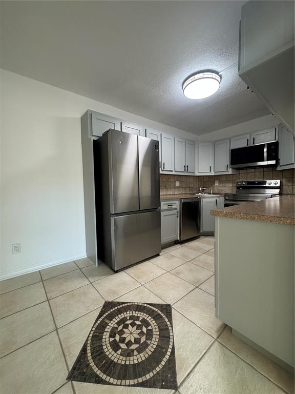 8213 Sun Spring Circle, Unit 61 Orlando, FL 32825 - Photo 12 of 44 a kitchen with stainless steel appliances granite countertop a refrigerator stove and microwave