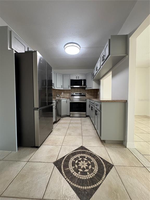 8213 Sun Spring Circle, Unit 61 Orlando, FL 32825 - Photo 13 of 44 a kitchen with stainless steel appliances granite countertop a refrigerator and a stove