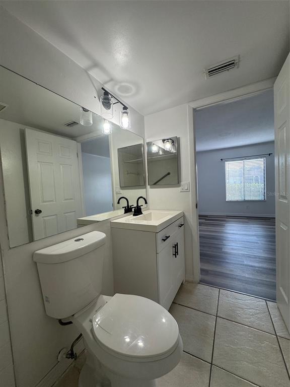 8213 Sun Spring Circle, Unit 61 Orlando, FL 32825 - Photo 26 of 44 a bathroom with a toilet sink and mirror