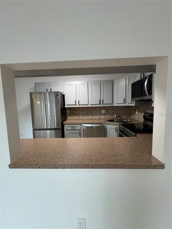 8213 Sun Spring Circle, Unit 61 Orlando, FL 32825 - Photo 10 of 44 a kitchen with stainless steel appliances granite countertop a refrigerator a stove and a sink with granite countertops