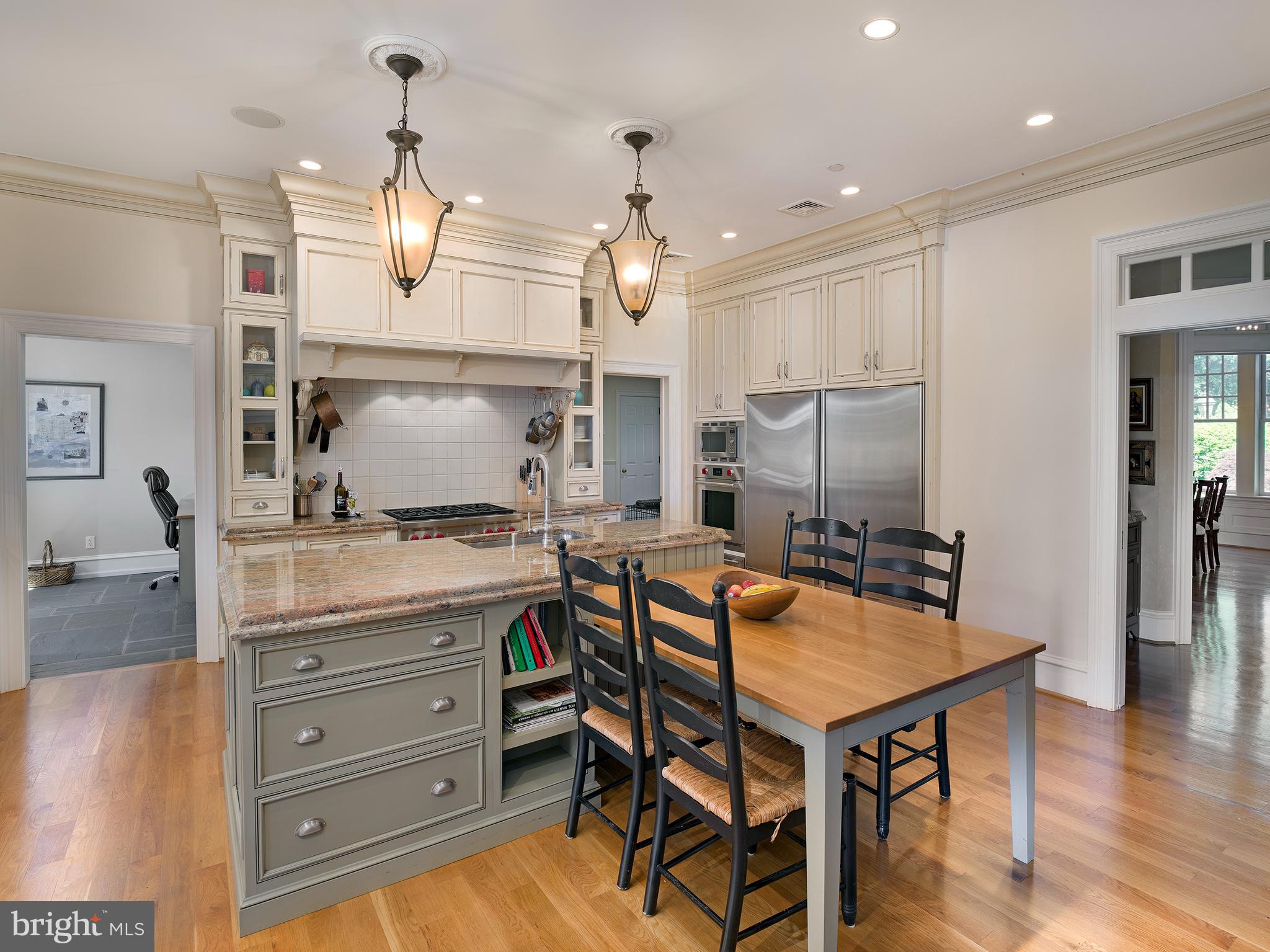 102 Springhouse Lane Newtown Square, PA 19073 - Photo 19 of 80 a kitchen with granite countertop a table chairs stainless steel appliances and wooden floor