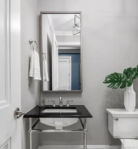 a bathroom with a sink a toilet and mirror