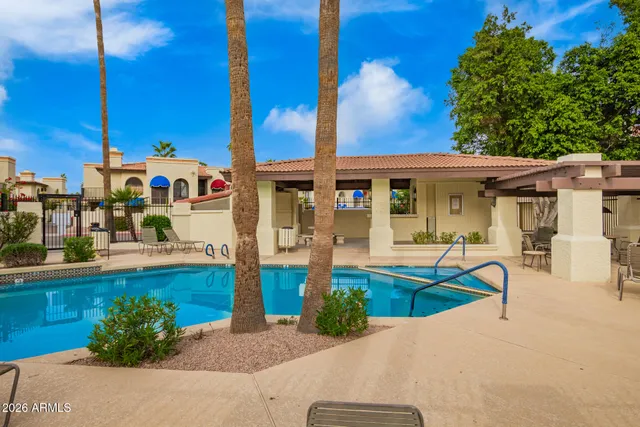a front view of a house with swimming pool and furniture