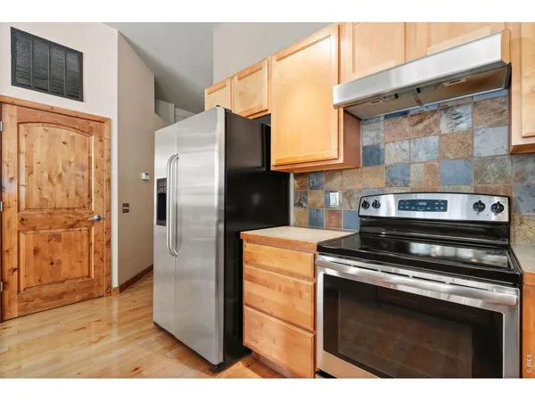 a kitchen with stainless steel appliances granite countertop a refrigerator stove and cabinets