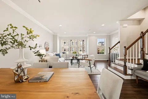 a living room with furniture a rug potted plant and a window
