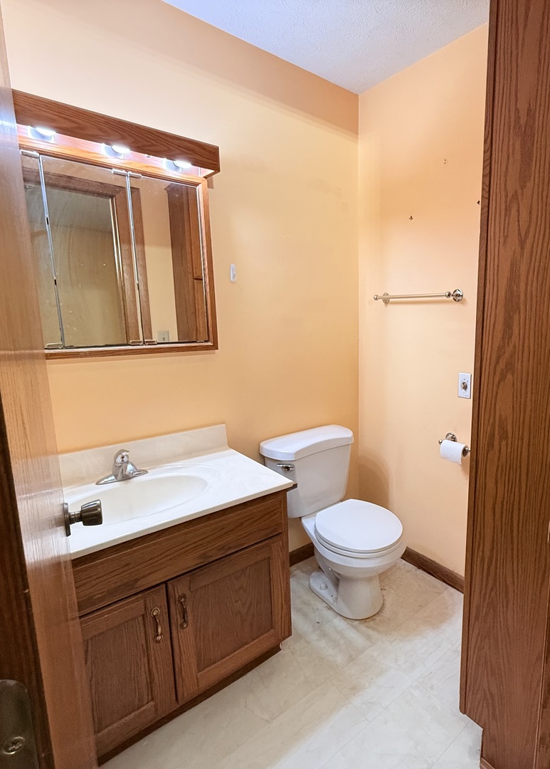 101 East 10th Street Gridley, IL 61744 - Photo 15 of 17 a bathroom with a toilet sink and mirror