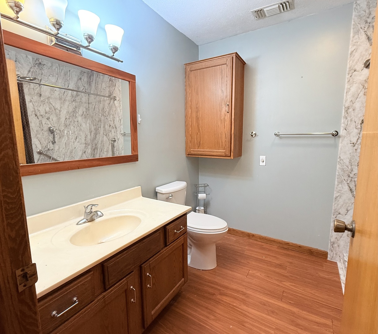 101 East 10th Street Gridley, IL 61744 - Photo 9 of 17 a bathroom with a sink mirror and toilet