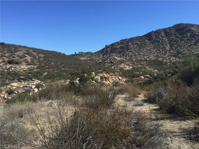 a view of a dry yard with mountains in the background