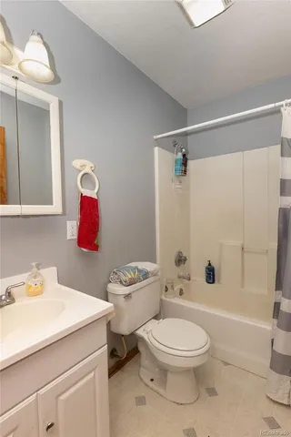 a bathroom with a toilet sink vanity tub and shower