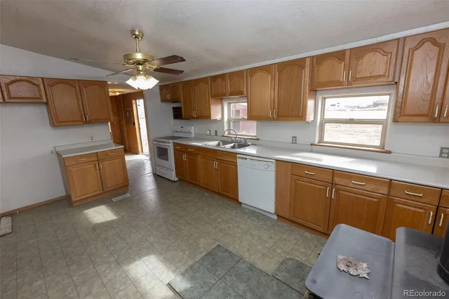 a kitchen with cabinets a sink stainless steel appliances and window