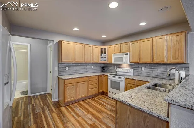 a kitchen with granite countertop wooden cabinets stainless steel appliances a sink and a counter top space