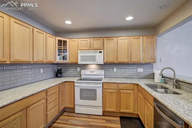 a kitchen with granite countertop white cabinets sink and stainless steel appliances
