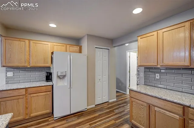 a kitchen with stainless steel appliances granite countertop a refrigerator and cabinets