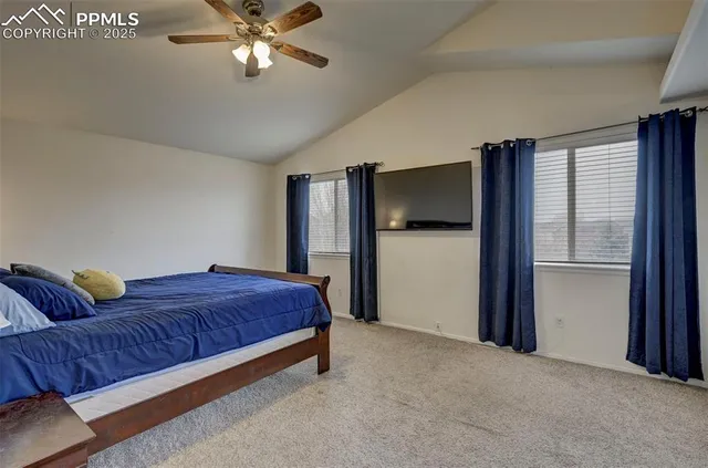 a spacious bedroom with a bed and a chandelier