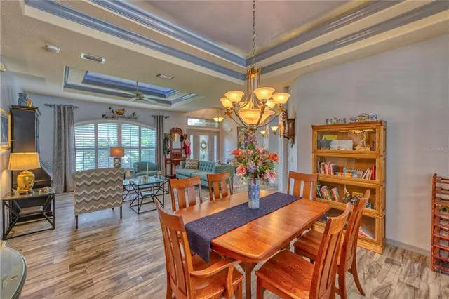a view of a dining room with furniture a chandelier and wooden floor