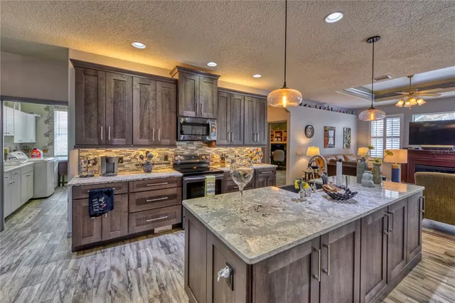 a kitchen with kitchen island granite countertop wooden cabinets and sink