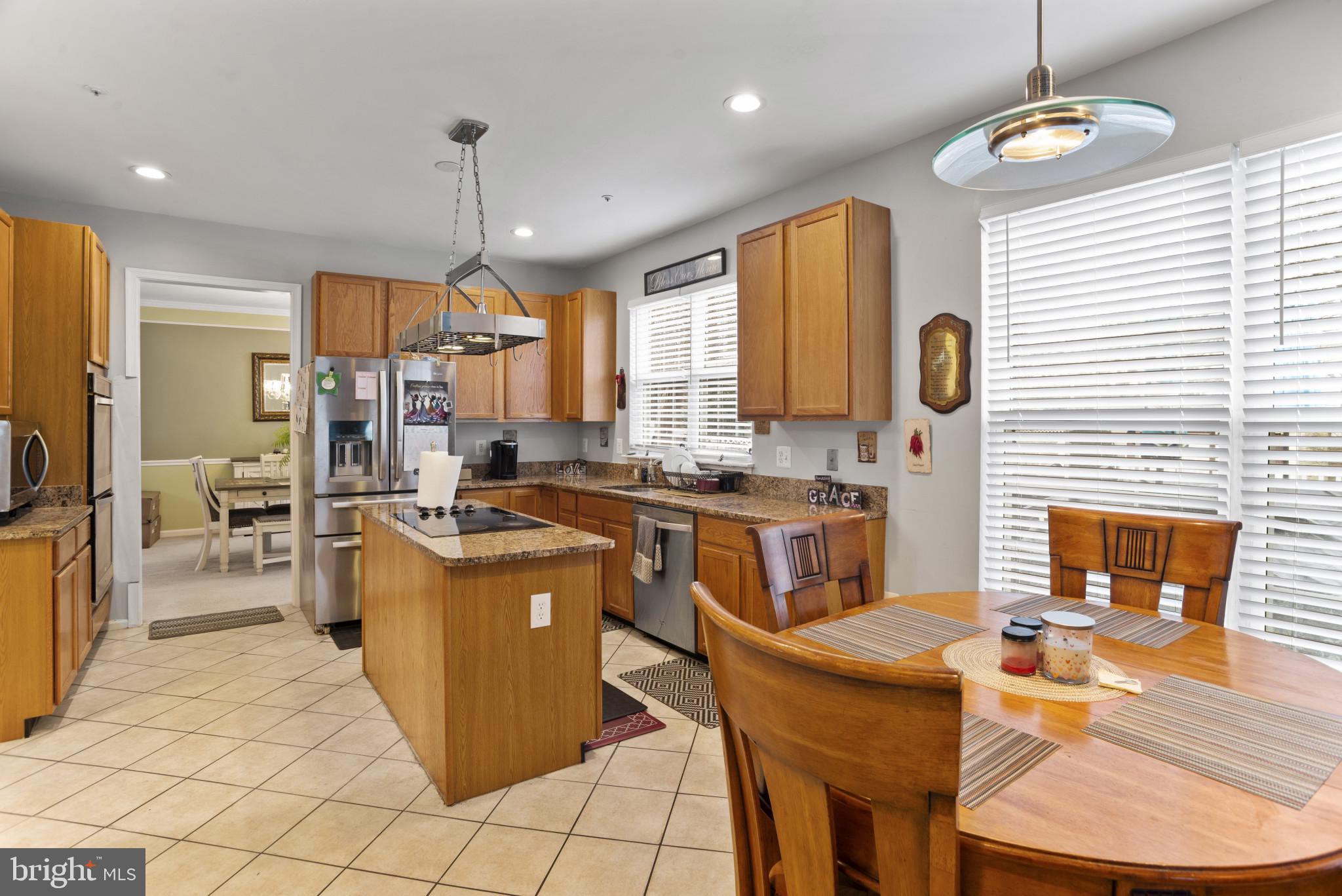 500 Treehouse Court Fort Washington, MD 20744 - Photo 10 of 25 a kitchen with stainless steel appliances kitchen island granite countertop a stove a sink a refrigerator and a dining table