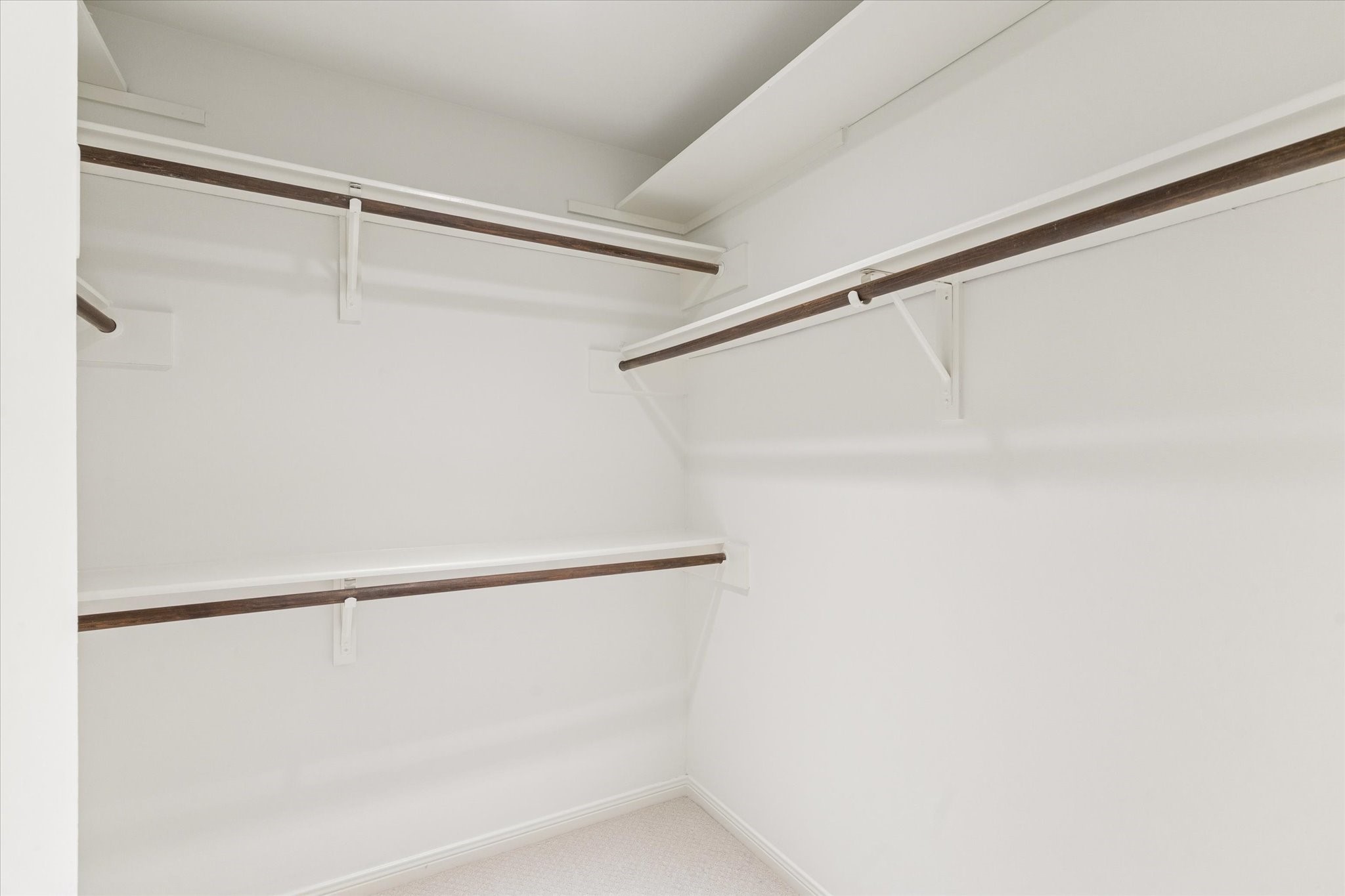 12 Lakeridge Drive Spring, TX 77381 - Photo 12 of 24 Spacious walk-in closet with custom built-in organization, double hanging rods, and fresh neutral carpet.