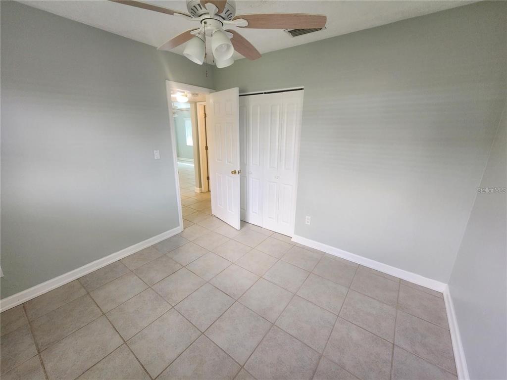 109 21st Street Northeast Bradenton, FL 34208 - Photo 7 of 14 an empty room with a chandelier fan and glass door