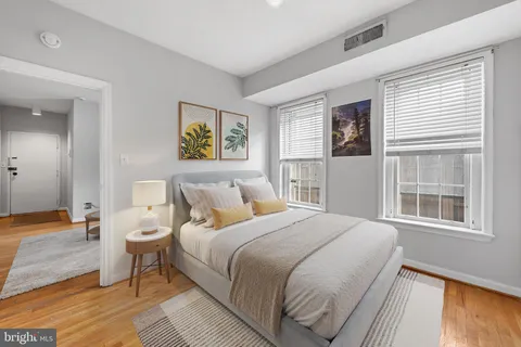 a bedroom with a bed and a large window