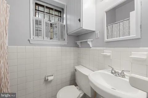 a bathroom with a sink a toilet and a mirror