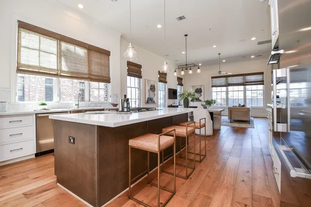 a large kitchen with lots of counter space a sink appliances and a large window