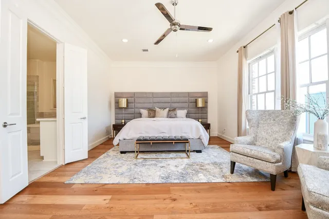 a bedroom with a large bed and wooden floor