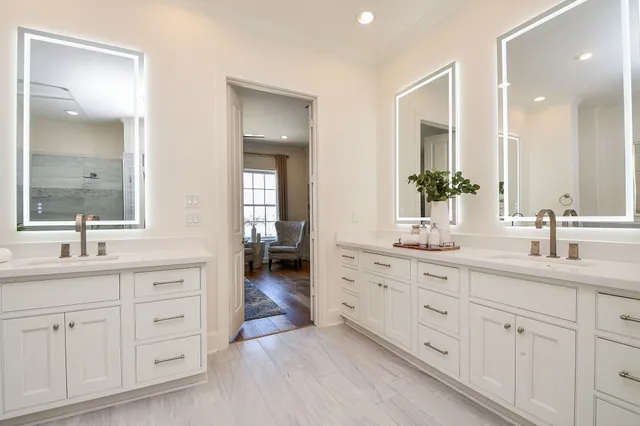 a spacious bathroom with double sink and a mirror