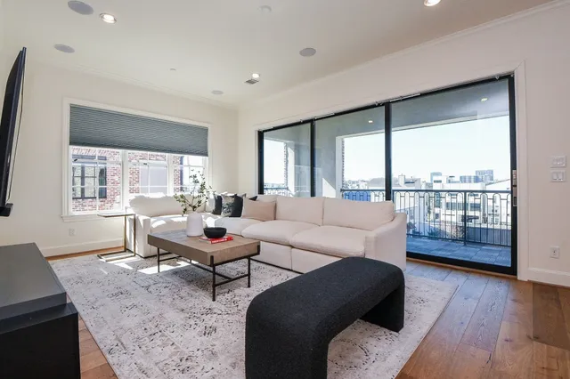 a living room with furniture and a wooden floor