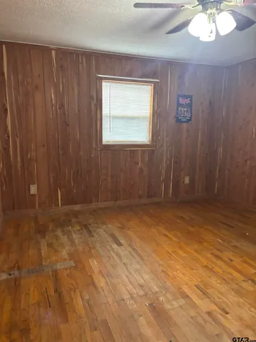 an empty room with a chandelier fan