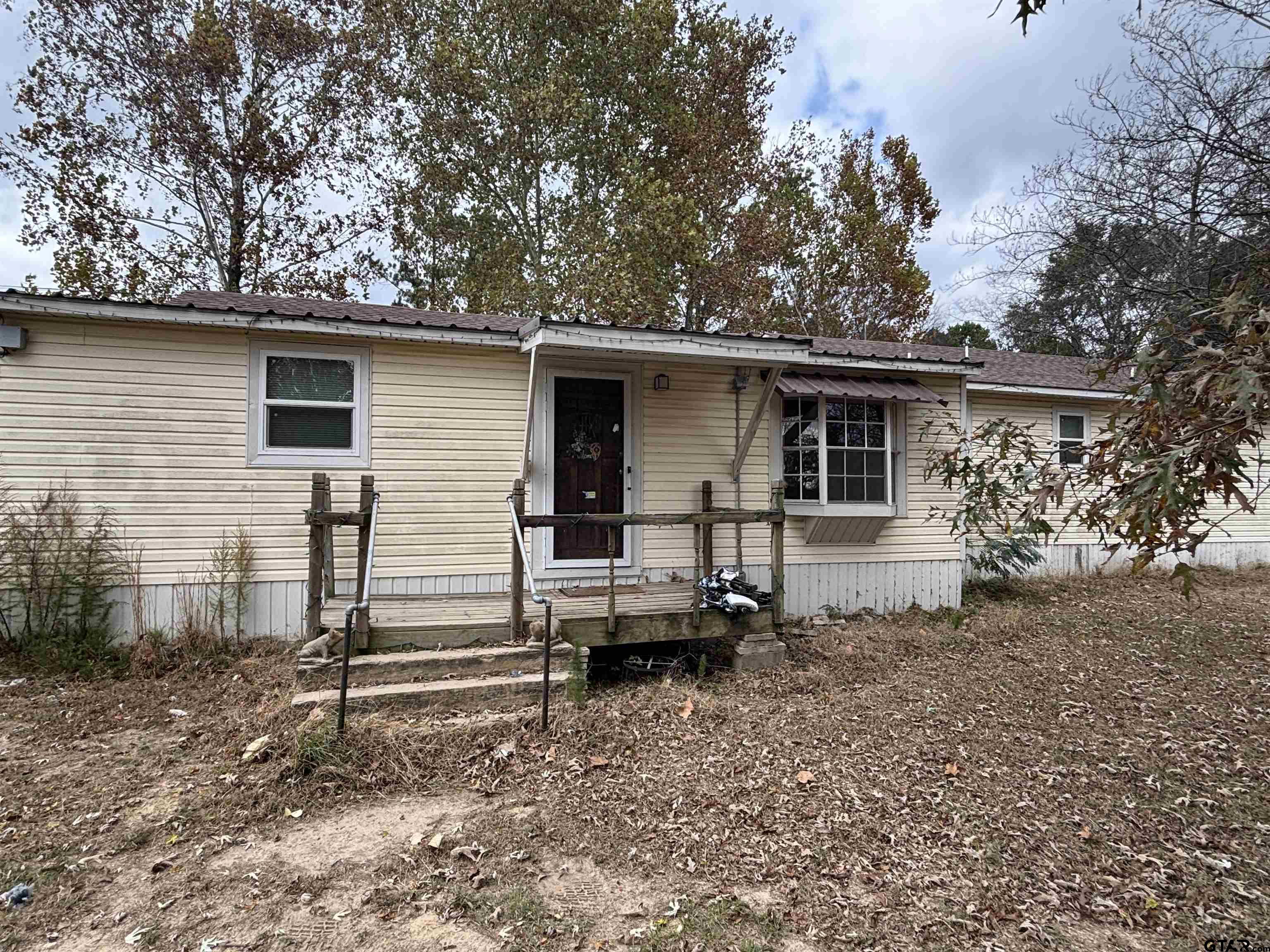 8123 Cherokee Trace Gilmer, TX 75644 - Photo 2 of 26 a view of a house with a yard chairs and wooden fence