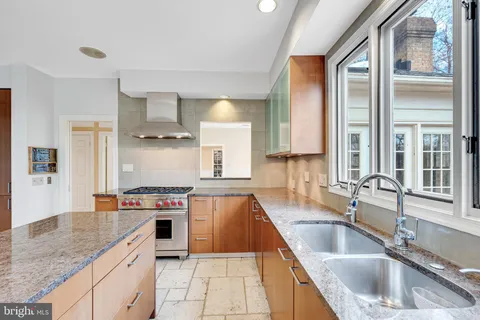a kitchen with stainless steel appliances granite countertop a sink stove and cabinets