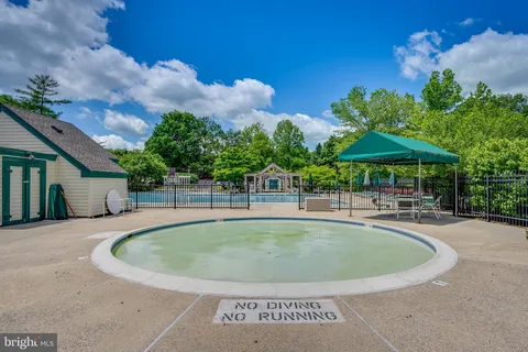 a view of a swimming pool with table and chairs under an umbrella
