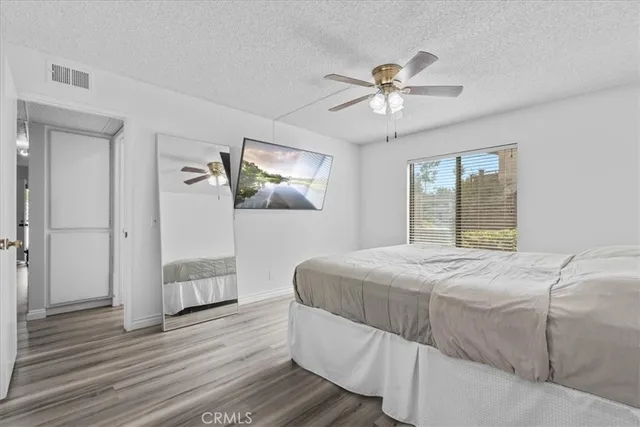 a bathroom with a granite countertop sink a toilet a mirror and shower