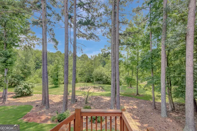 a view of swimming pool with lawn chairs and plants