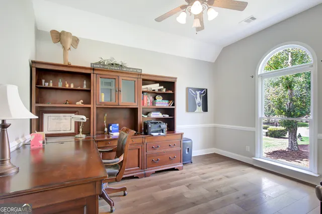 a view of a workspace with furniture and a window