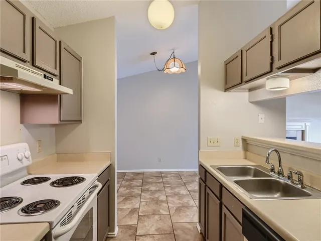 a kitchen with stainless steel appliances granite countertop a sink and a stove
