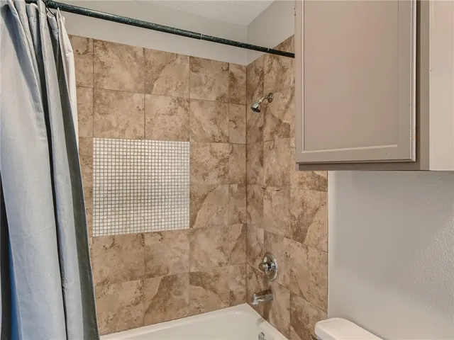 a bathroom with a shower toilet and sink