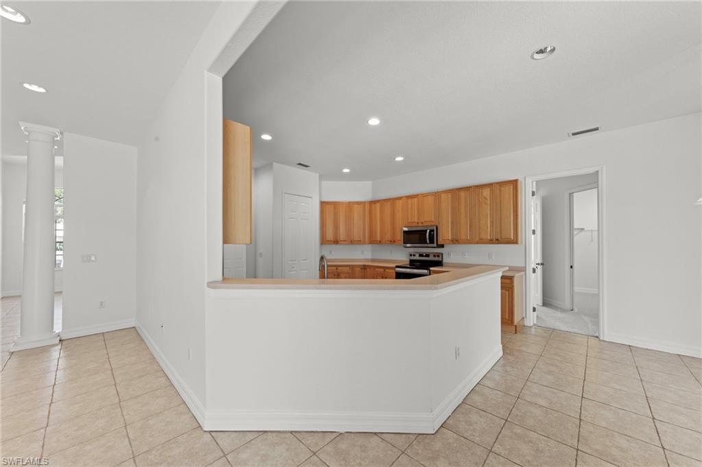 9623 Springlake Circle Estero, FL 33928 - Photo 14 of 47 a kitchen with stainless steel appliances a refrigerator and a stove top oven