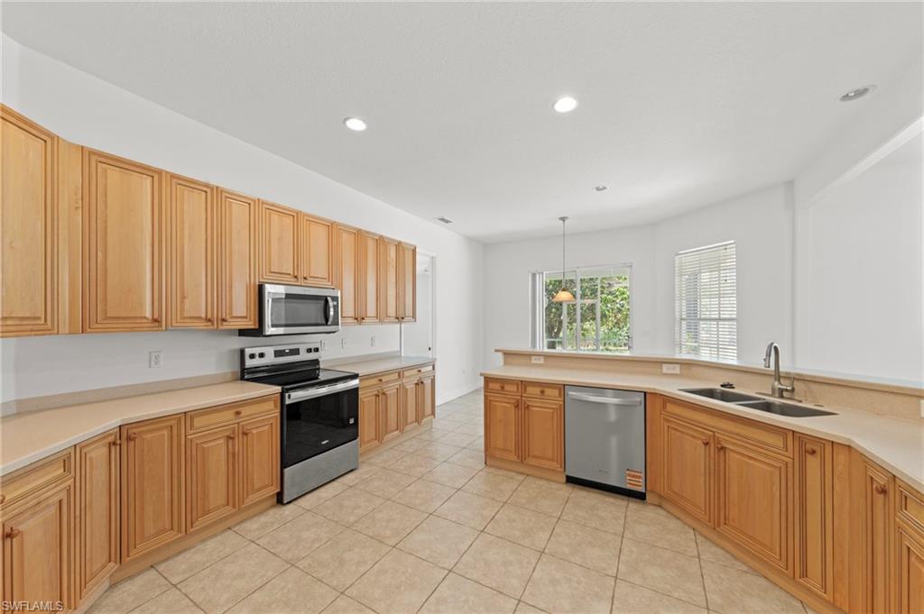 9623 Springlake Circle Estero, FL 33928 - Photo 18 of 47 a kitchen with stainless steel appliances a stove sink and microwave