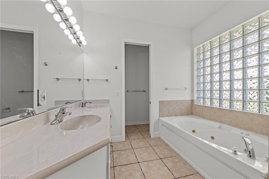 9623 Springlake Circle Estero, FL 33928 - Photo 24 of 47 a bathroom with a tub a sink and mirror